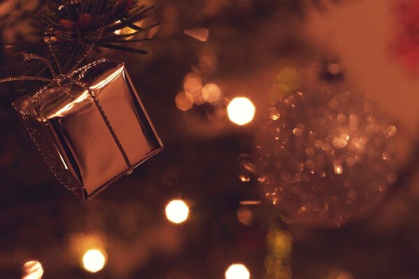 Bolas de Navidad y un regalo en el fondo de las luces