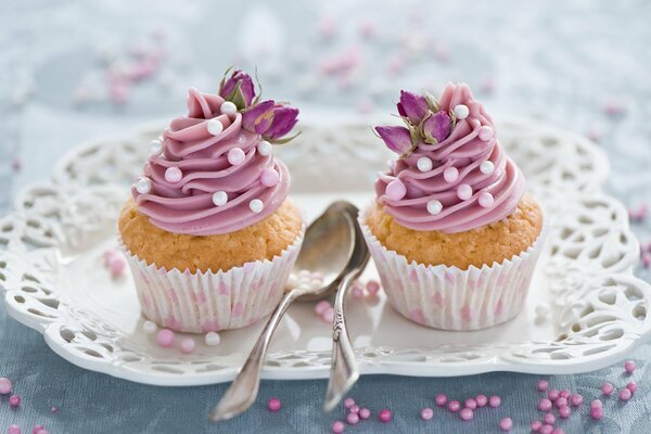 Muffins mit Cremetürmchen auf einem durchbrochenen Teller