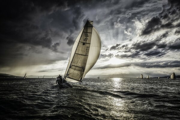 Segelboot im grauen Meer unter Wolken