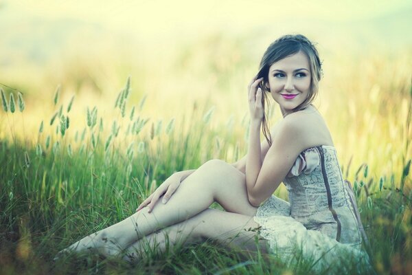 Hermosa chica en la hierba en el campo