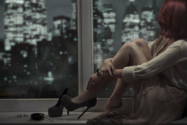 Sad girl at the window in shoes