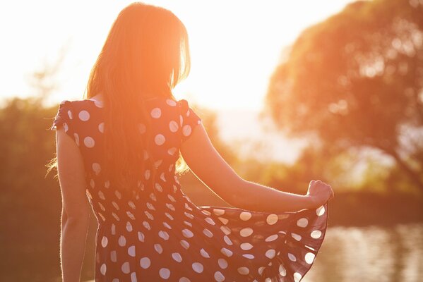 Morena en vestido en el río por la mañana