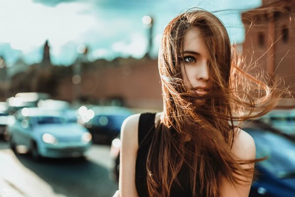 A girl with long hair on the background of the city