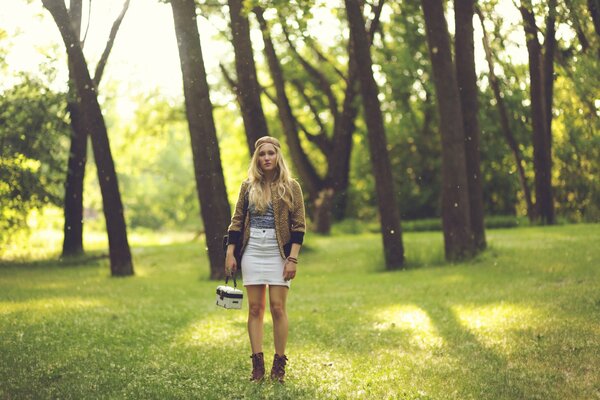 Blonde girl standing in the woods