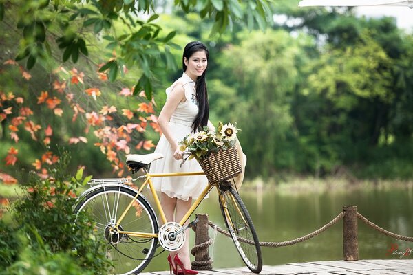 Asian woman in a white raincoat on a bicycle