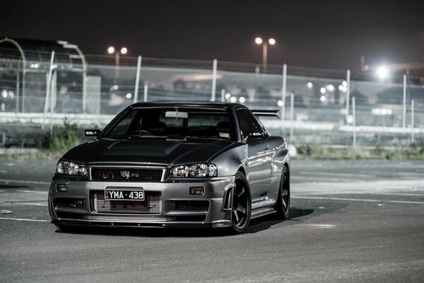 Black Nissan at night in the parking lot