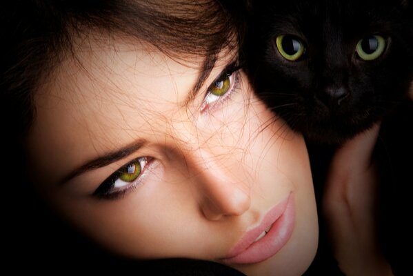 Chica de ojos verdes con un gato negro de ojos verdes