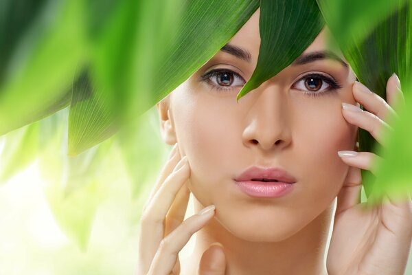 Beautiful girl in green foliage