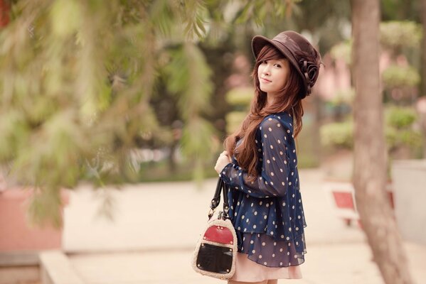 Asian girl with a handbag in a hat