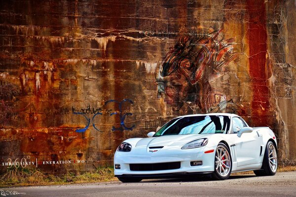 Biała Chevrolet Corvette C6 na tle grunge ściany z graffiti