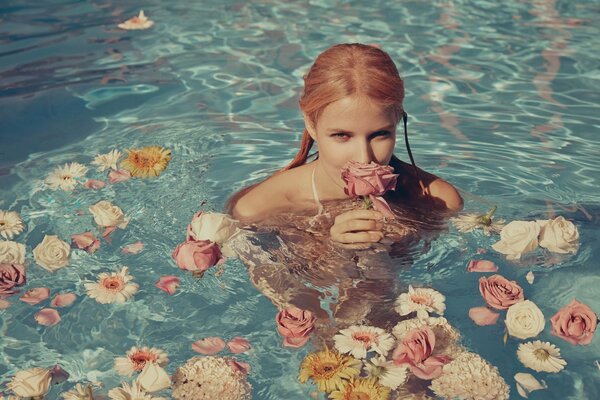 Ragazza con fiori in mano in acqua