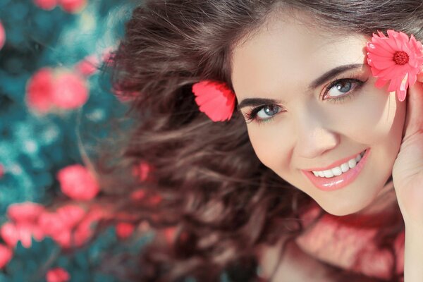 Cute curly-haired girl on a background of flowers