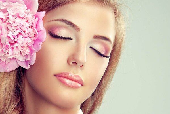 Hermosa chica con una flor rosa