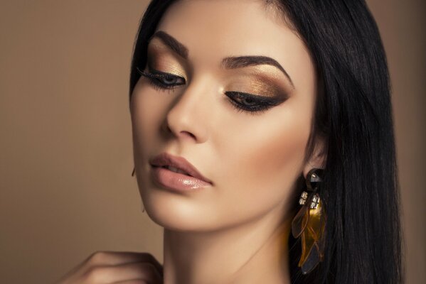 Modelo con maquillaje en tonos dorados