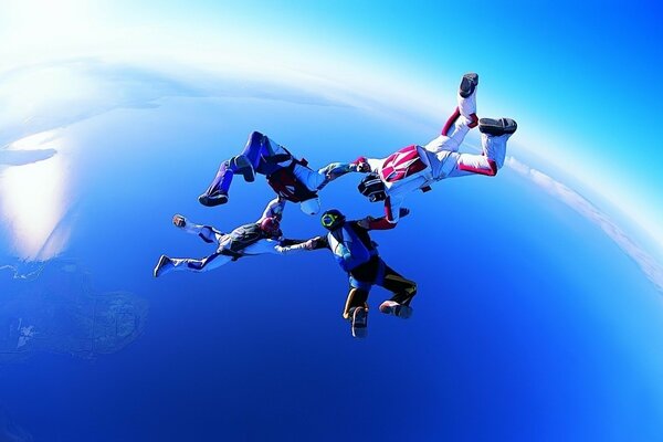 Parachutists in free flight hold hands