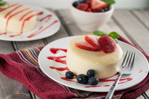 Dessert rotondo su un piatto con fragole e mirtilli