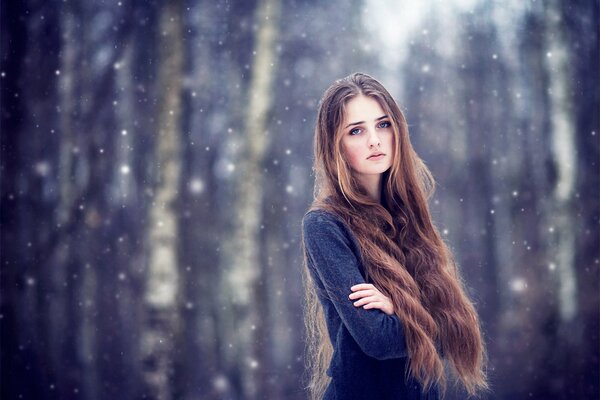 A girl in light clothes poses in the forest