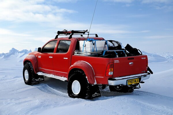 Toyota rouge au pôle Nord en hiver au milieu de la neige