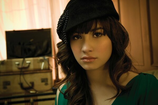 A girl in a black beret on the background of a TV