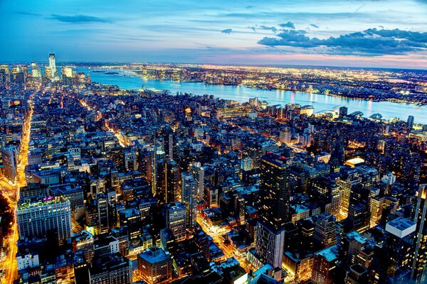 Ville du soir de New York avec des gratte-ciel de lumières de la rivière et beau ciel