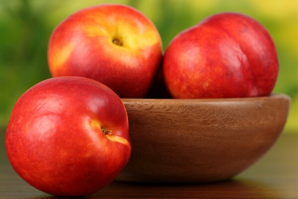 Peaches in a tawak on the table and a green background