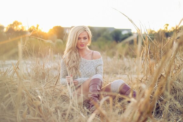 A girl in boots and a sweater on the field