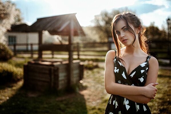 Russian girl on the background of a village well