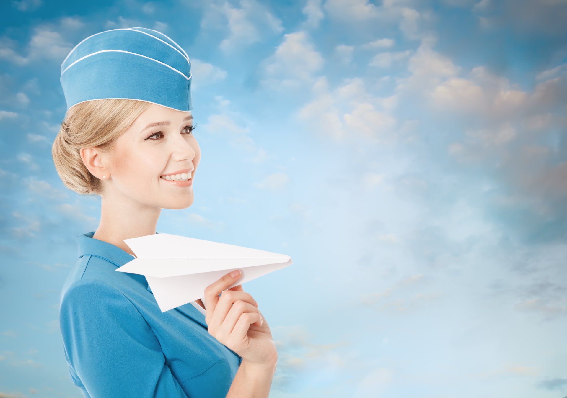 mädchen blond stewardess lächeln papierflugzeug uniform