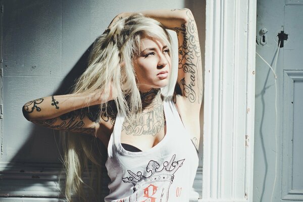 Chica rubia en camiseta blanca con tatuaje