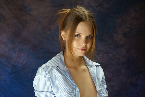 A gray-eyed brown-haired woman with her hair pulled back and an unbuttoned shirt
