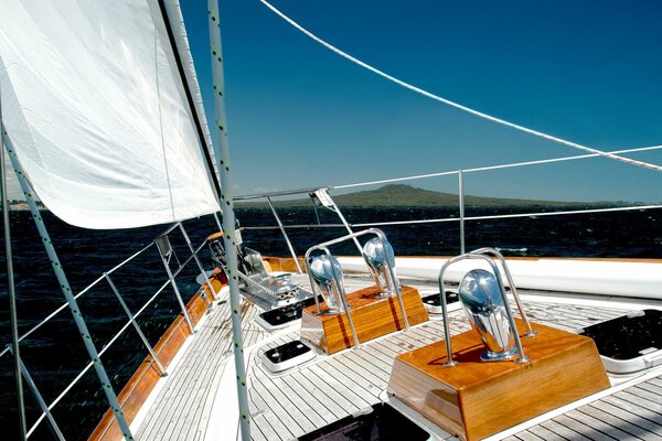 Yacht with a sail on a blue sky background