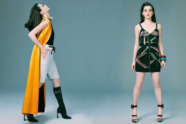 Two model girls at a photo shoot on a gray background