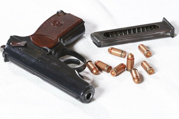 Makarov pistol with cartridges on a white background