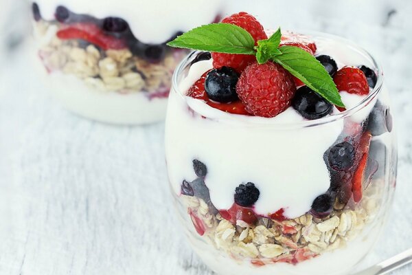 Delicious dessert in a glass of muesli , ice cream and berries