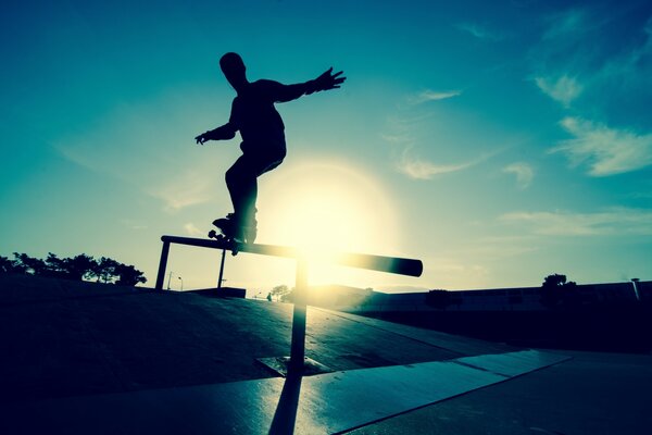 Skateboarder esegue trucchi contro il sole
