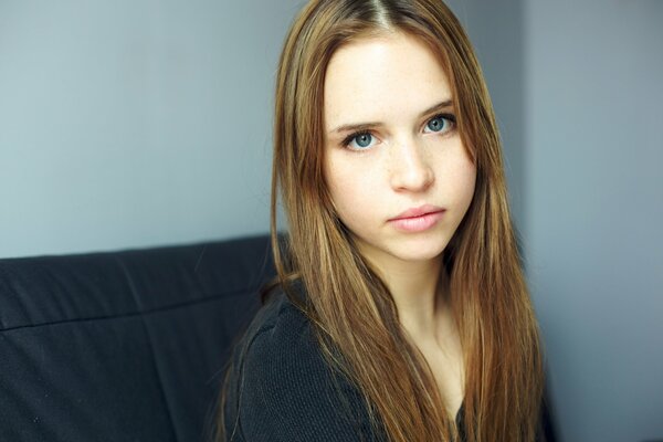 A girl with blue eyes looks seriously at the camera