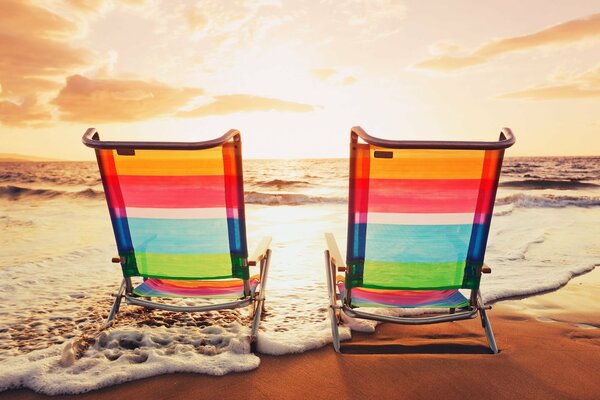 Zwei Liegen auf dem Hintergrund des Meeres am Strand