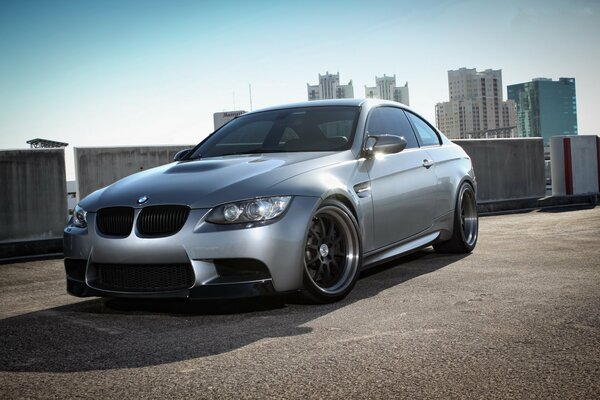 Silver BMW on the background of skyscrapers