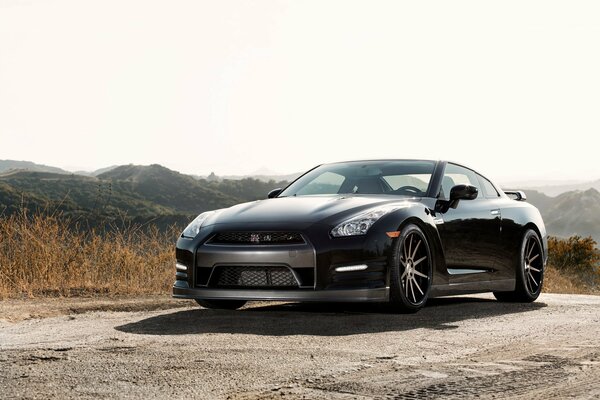 Black Nissan posing near the mountains