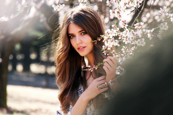 Model Clara Alonso holds a sakura branch