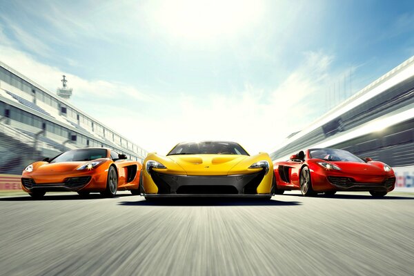 Three McLarens orange yellow and red