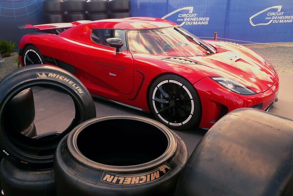 Red sports car among the tires