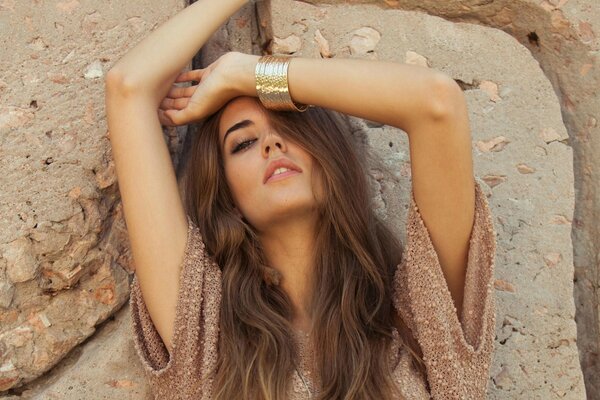 Clara Anso in a pose with her hands up in brown tones