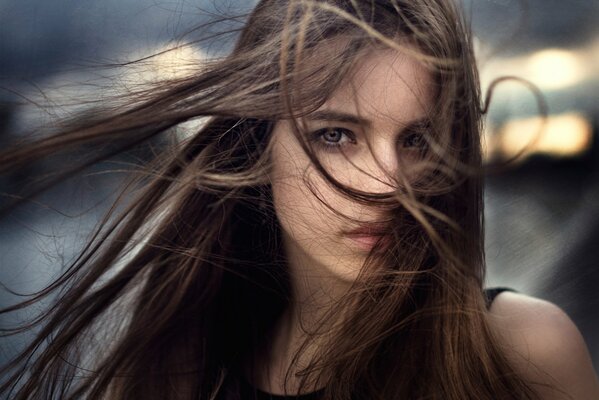 A girl with developing long hair looks at the camera