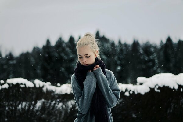 The blonde girl wrapped herself in a black scarf