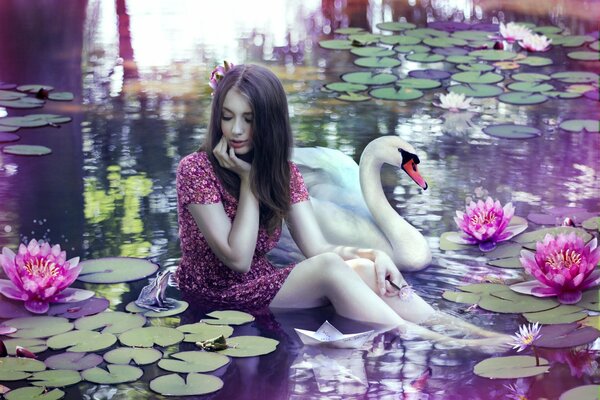 A girl in a pond with a swan among lotuses