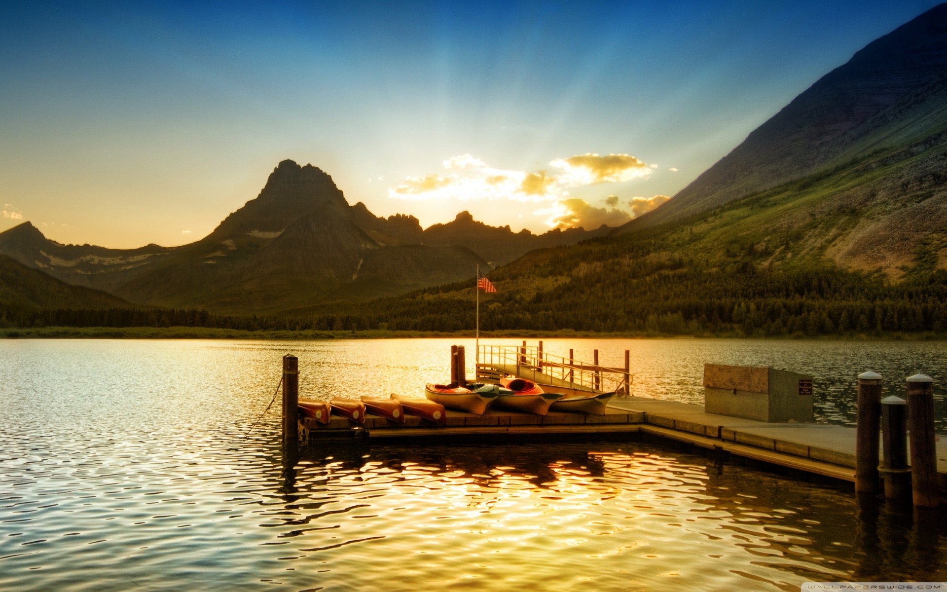 coucher de soleil jetée bateaux montagnes lac