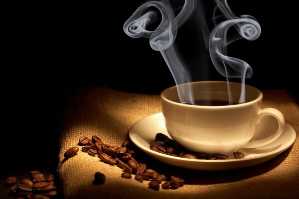 The aroma of coffee. Steam from the cup. Coffee beans. A cup of fragrant hot coffee