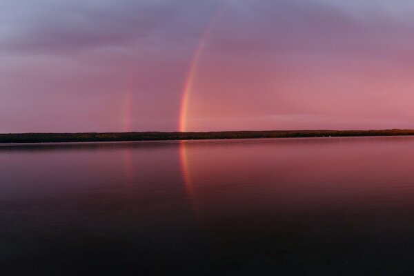 Un arco iris extraordinario por la noche en una foto panorámica
