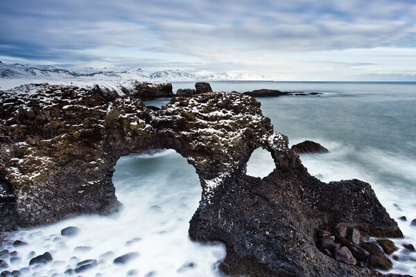 Clouds over the winter sea and rocks